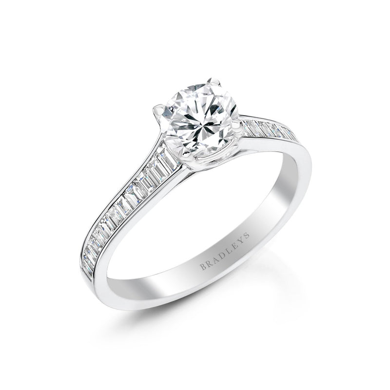 side angle of round brilliant cut engagement ring  with elegant baguette cut diamond shoulders