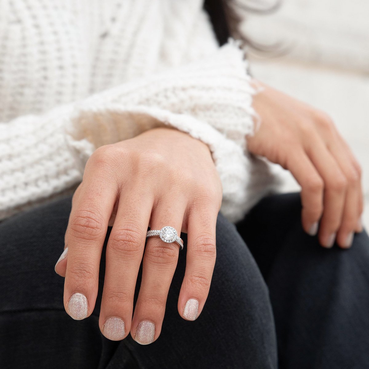 lady wearing split shoulder diamond halo ring