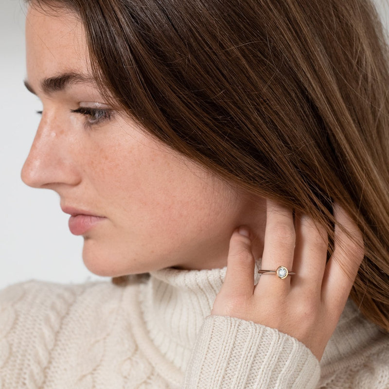 side angle of lady in white jumper wearing two tone engagement ring