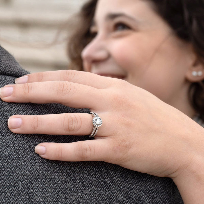 lady wearing platinum coloured diamond halo engagement ring with split shoulders